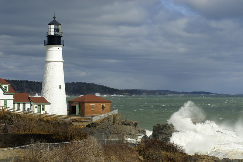 Sunlight Breaks Through Clouds on Portland Lighthouse with Huge Waves
