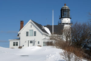 Snow drifts around Cape Elizabeth Lighthouse after storm.