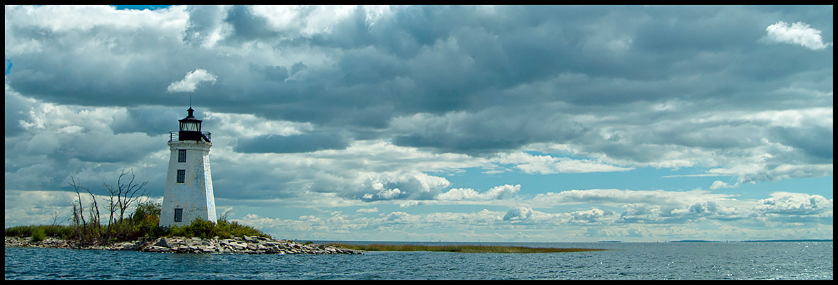 Sun breaking through clouds at Black Rock Harbor light