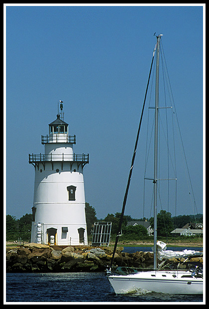 sailboat passes Saybrook Breakwater light