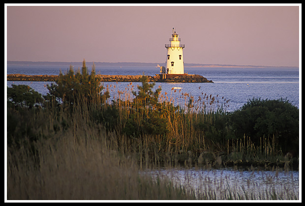 sun setting by Saybrook Breakwater light 