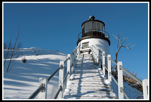 Owls Head lighthouse with stairway after snowstorm