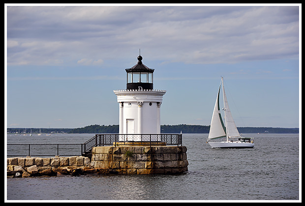 sailboat passes by Portland Breakwater lighthouse