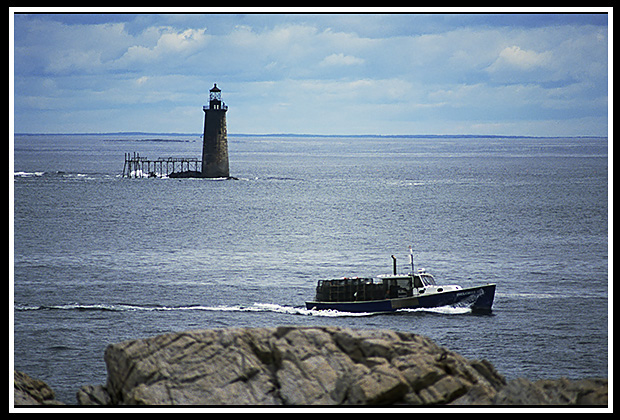 lobsterboat passes by Ram Island lighthouse