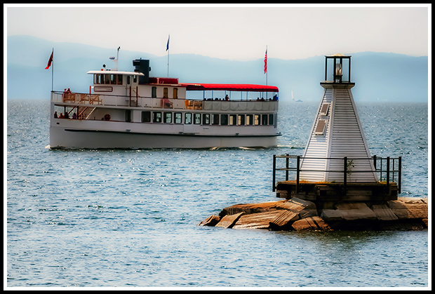 boat passing by Burlington Breakwater South light