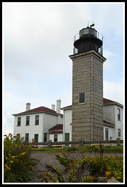 sun breaks through clouds at Beavertail lighthouse