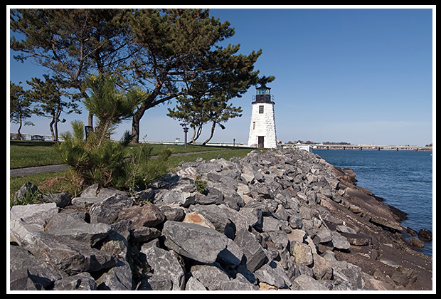 Newport Harbor lighthouse with stone breaker for protection